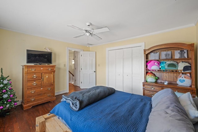 bedroom featuring dark wood-type flooring, ceiling fan, ornamental molding, and a closet