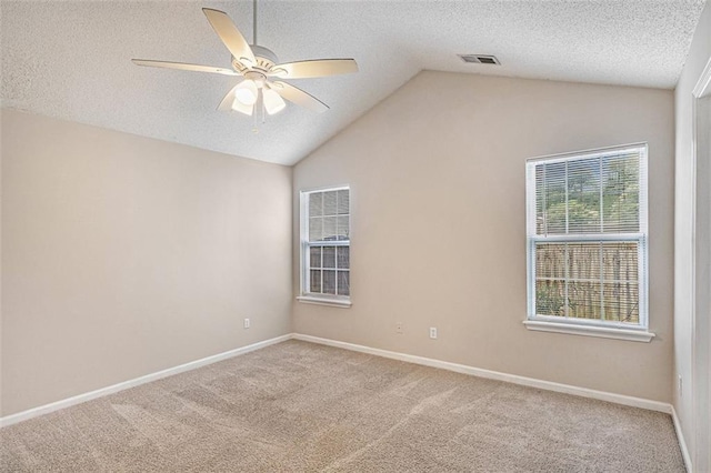 carpeted spare room with lofted ceiling, a textured ceiling, and ceiling fan