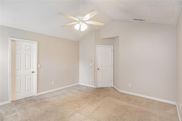 carpeted spare room with ceiling fan, a textured ceiling, and vaulted ceiling