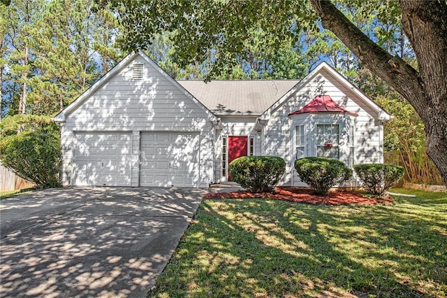 tudor house featuring a garage and a front lawn