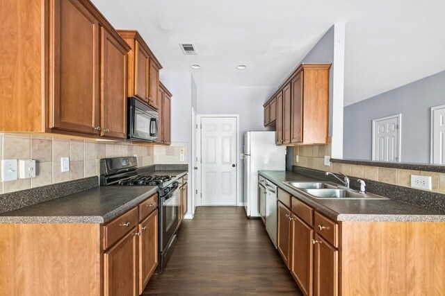 2872 Cross Creek Ct, Cumming, GA 30040 - kitchen featuring dark countertops, tasteful backsplash, a sink, stainless steel appliances, and visible vents
