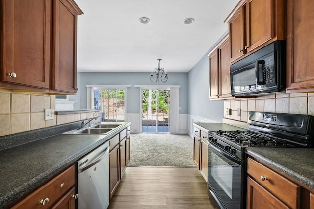2872 Cross Creek Ct, Cumming, GA 30040 - kitchen with a wainscoted wall, dark countertops, wood finished floors, a sink, and black appliances