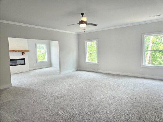 195 Silvercrest Dr, Acworth, GA 30101 - unfurnished living room with healthy amount of natural light, crown molding, baseboards, carpet flooring, and a glass covered fireplace