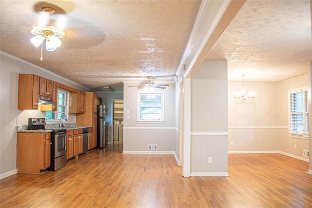 kitchen featuring brown cabinets, light wood finished floors, stainless steel appliances, washing machine and dryer, and under cabinet range hood