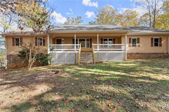 rear view of property with covered porch, a lawn, and crawl space