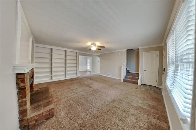 unfurnished living room with crown molding, ceiling fan, carpet flooring, and built in features