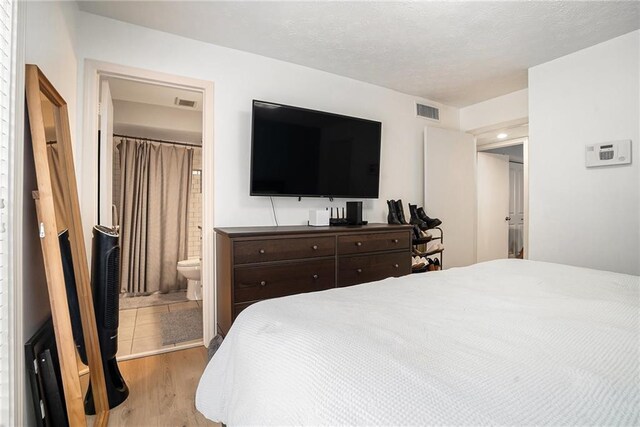 bedroom featuring light hardwood / wood-style floors and connected bathroom