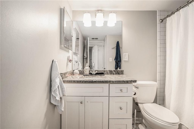 bathroom with toilet, vanity, and walk in shower