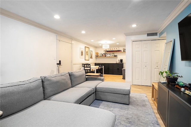 living room featuring light hardwood / wood-style floors and crown molding