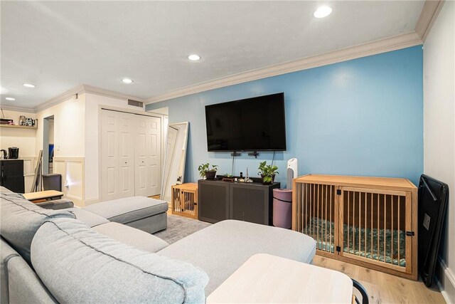 living room with light hardwood / wood-style flooring and ornamental molding