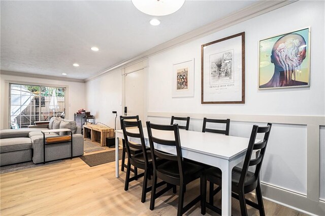 dining room featuring light hardwood / wood-style flooring and ornamental molding