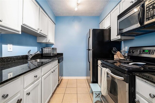 kitchen featuring sink, white cabinetry, track lighting, and appliances with stainless steel finishes