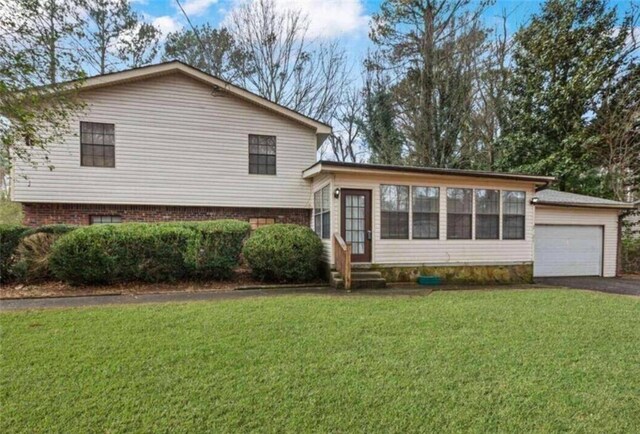 split level home with entry steps, a front lawn, driveway, and a garage