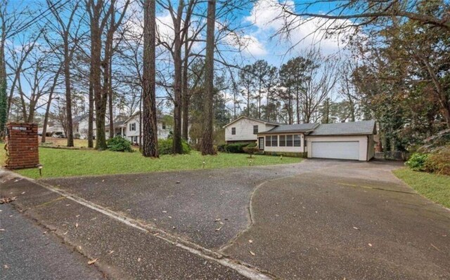 split level home featuring a front lawn, driveway, and a garage