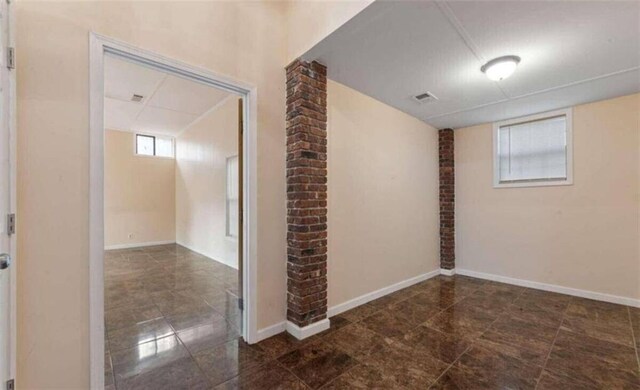 interior space featuring dark tile patterned floors, visible vents, and baseboards