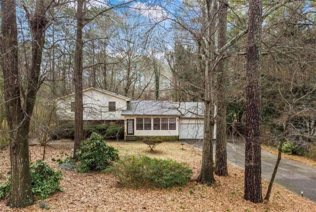 tri-level home with aphalt driveway and an attached garage
