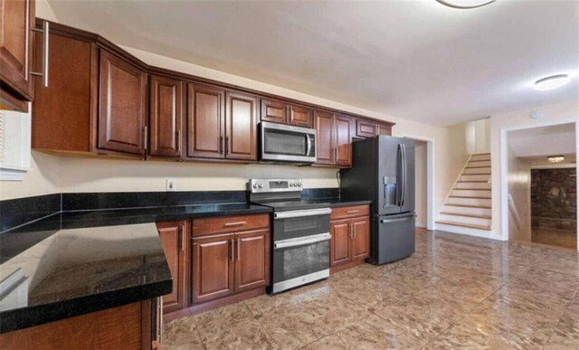 kitchen with dark countertops and appliances with stainless steel finishes