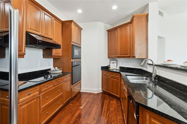 2828 Peachtree Rd NW Unit 1502, Atlanta, GA 30305 - kitchen with under cabinet range hood, black appliances, dark wood finished floors, dark stone countertops, and recessed lighting