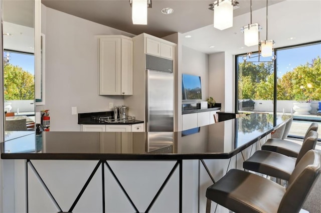 2828 Peachtree Rd NW Unit 1502, Atlanta, GA 30305 - kitchen with built in refrigerator, dark countertops, healthy amount of natural light, white cabinets, and recessed lighting