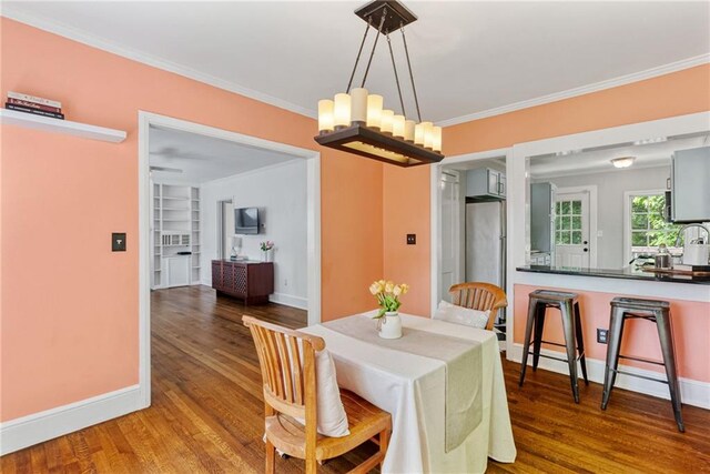 131 Lively St, Norcross, GA 30071 - dining space with wood finished floors, baseboards, crown molding, and a chandelier