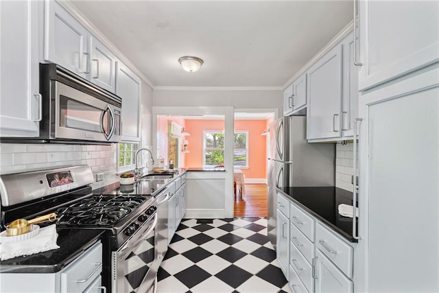 131 Lively St, Norcross, GA 30071 - kitchen featuring appliances with stainless steel finishes, light flooring, a sink, dark countertops, and tasteful backsplash