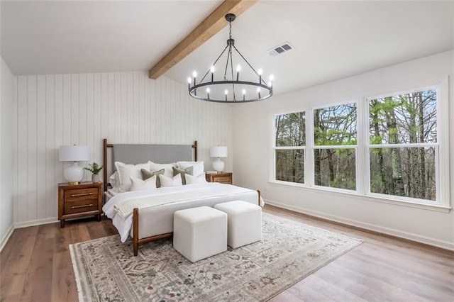 bedroom featuring vaulted ceiling with beams, a notable chandelier, wood finished floors, visible vents, and baseboards