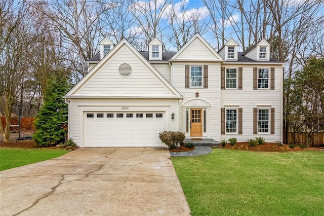 colonial-style house with an attached garage, fence, concrete driveway, and a front yard