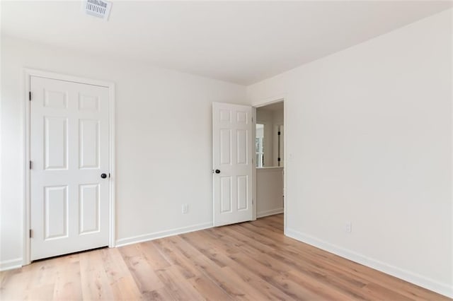 unfurnished bedroom with light wood-type flooring, baseboards, and visible vents