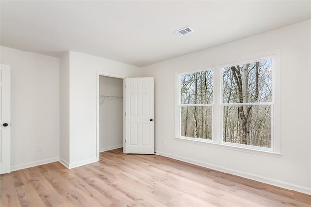 unfurnished bedroom with light wood-type flooring, visible vents, and baseboards