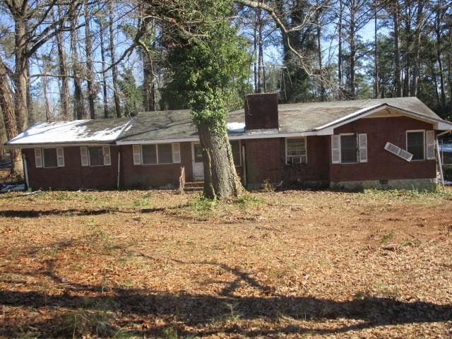 view of front of home with crawl space and a chimney