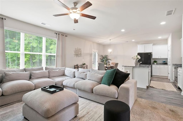 living area featuring ceiling fan, wood finished floors, and recessed lighting