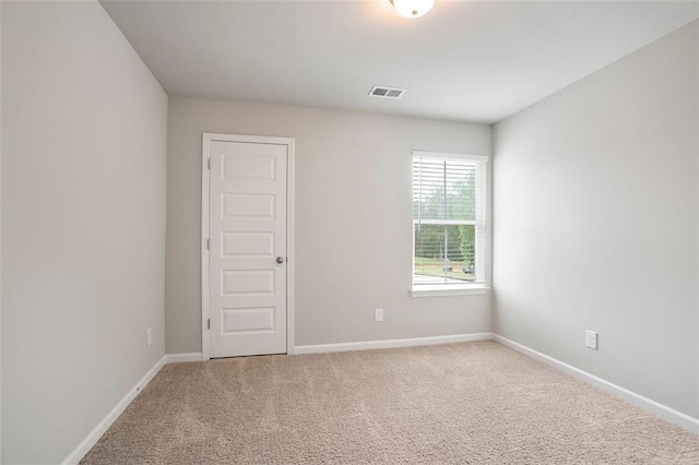carpeted spare room featuring baseboards
