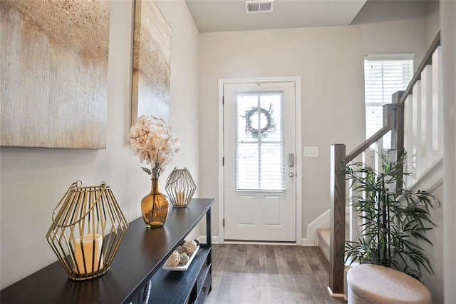 doorway with stairs, wood finished floors, and baseboards
