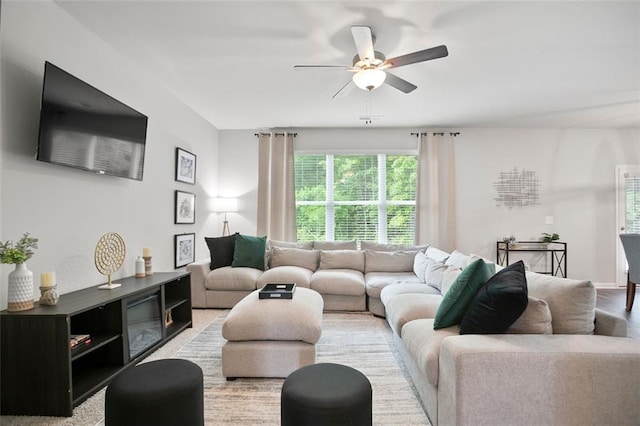 living area with a ceiling fan and light wood-style flooring