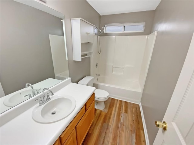 full bath featuring shower / bathtub combination, toilet, wood finished floors, and vanity