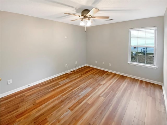 empty room with visible vents, baseboards, light wood finished floors, and ceiling fan