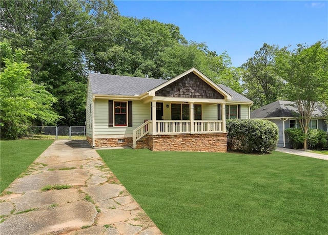 view of front facade featuring fence, concrete driveway, a porch, and a front lawn