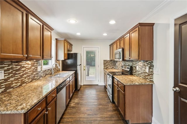 kitchen with decorative backsplash, dark wood-style flooring, a sink, ornamental molding, and stainless steel appliances