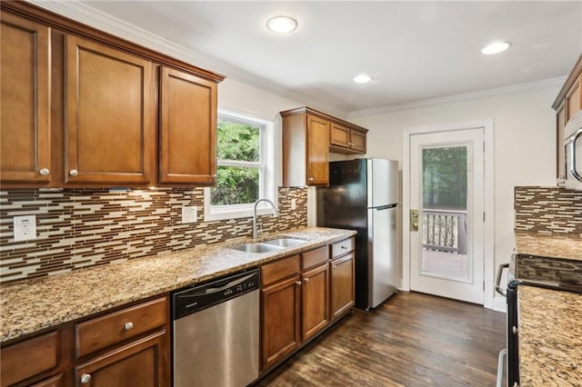 kitchen featuring a sink, ornamental molding, stainless steel appliances, and dark wood-style floors
