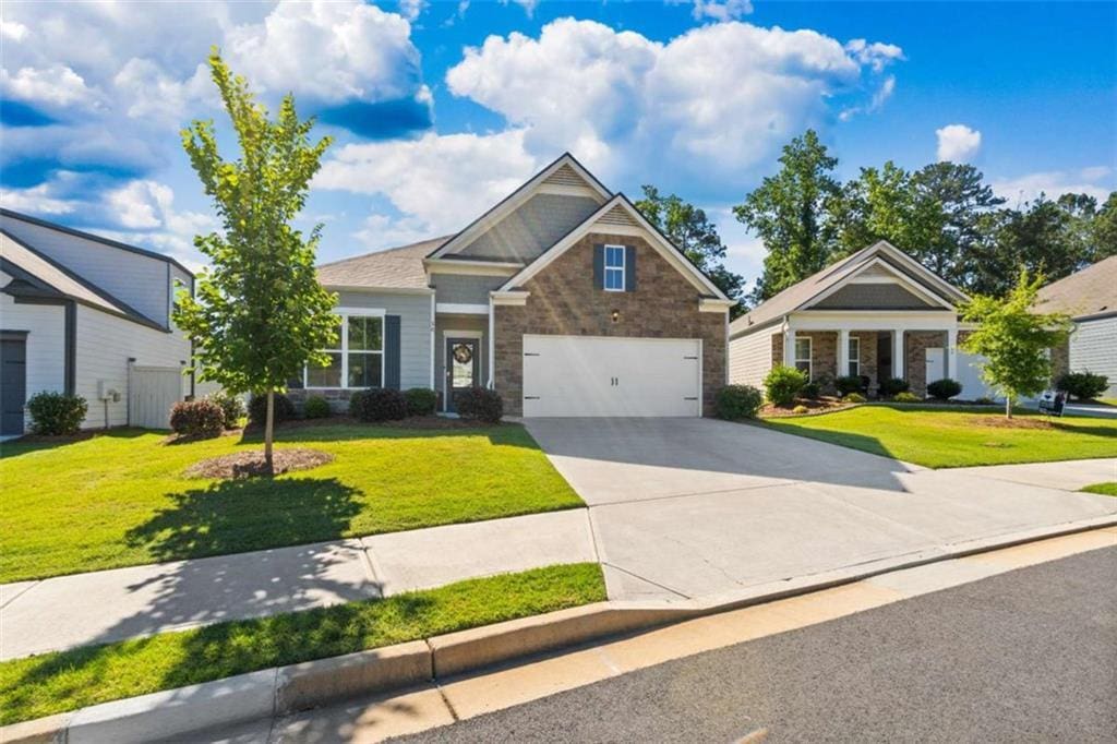 craftsman house with a garage and a front lawn