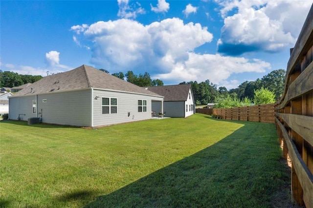 rear view of property featuring a yard and cooling unit