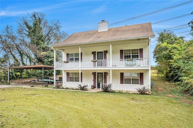 view of front of house featuring a front yard, roof with shingles, covered porch, a chimney, and a carport