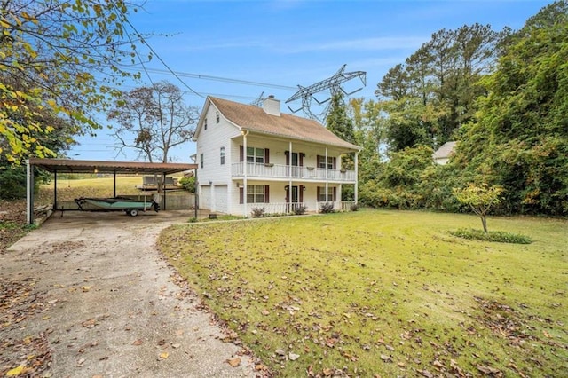 view of front of home featuring driveway, a porch, a chimney, a carport, and a front lawn