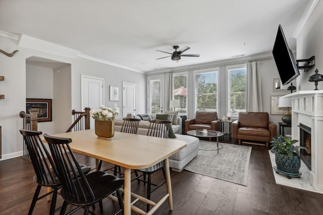 243 Retreat Ln, Canton, GA 30114 - dining space with a warm lit fireplace, a ceiling fan, ornamental molding, dark wood-style flooring, and baseboards