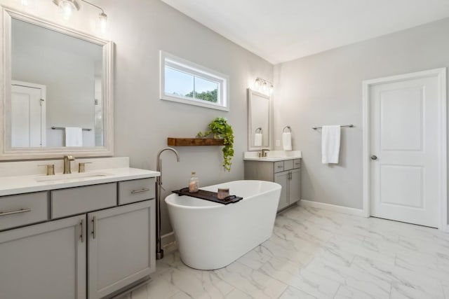 243 Retreat Ln, Canton, GA 30114 - bathroom featuring marble finish floors, two vanities, a freestanding bath, and baseboards