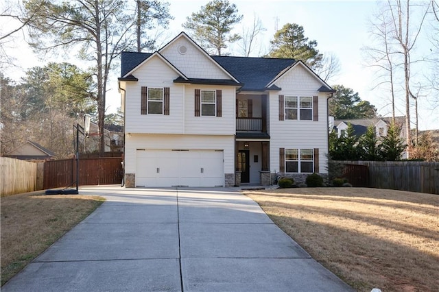 view of front of home featuring driveway, a front lawn, stone siding, and fence