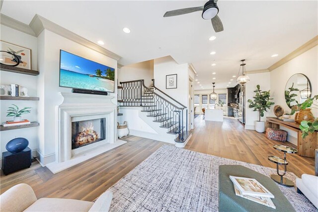 661 Auburn Ave NE Unit 10, Atlanta, GA 30312 - living room with wood finished floors, a lit fireplace, stairs, ceiling fan, and ornamental molding