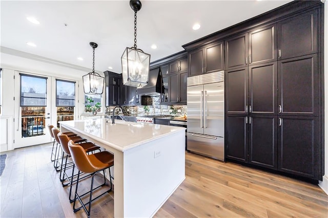 661 Auburn Ave NE Unit 10, Atlanta, GA 30312 - kitchen with built in refrigerator, custom exhaust hood, a breakfast bar, light wood-type flooring, and a chandelier