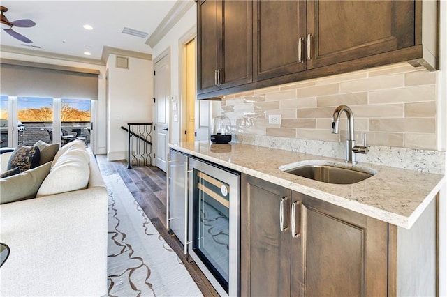 661 Auburn Ave NE Unit 10, Atlanta, GA 30312 - kitchen with beverage cooler, decorative backsplash, dark brown cabinets, light stone counters, and open floor plan