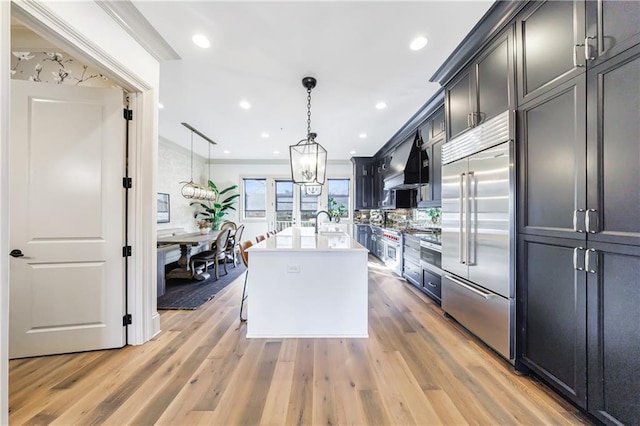 661 Auburn Ave NE Unit 10, Atlanta, GA 30312 - kitchen with built in fridge, light countertops, light wood finished floors, a center island with sink, and pendant lighting